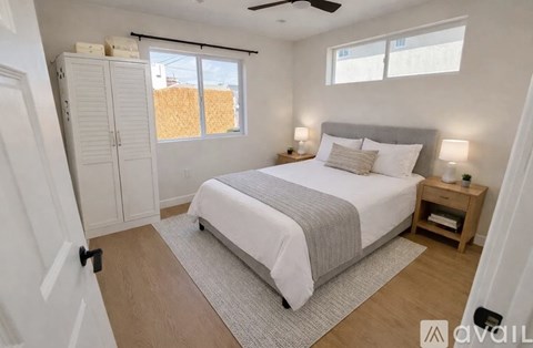A bedroom with a large bed and a ceiling fan.