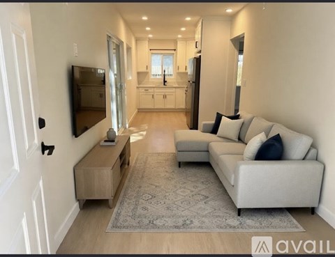 A modern living room with a grey sofa and a television.
