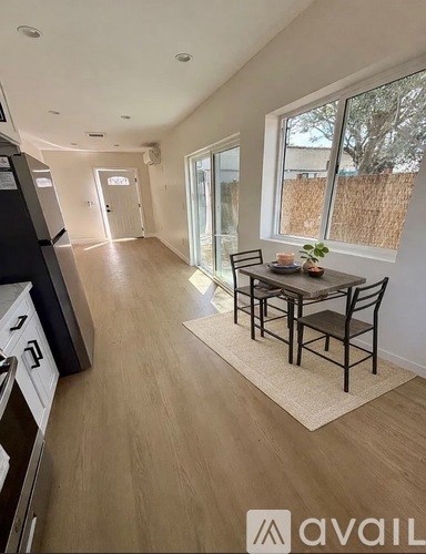 A kitchen with a dining table and chairs in the middle of the room.