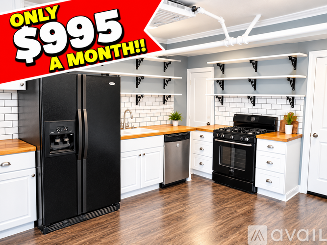 A kitchen with a black fridge and a sign that says $995 a month.