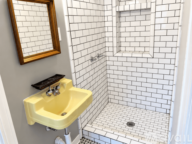 A bathroom with a yellow sink and a mirror.
