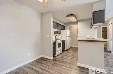 A kitchen with a white counter and a fridge.