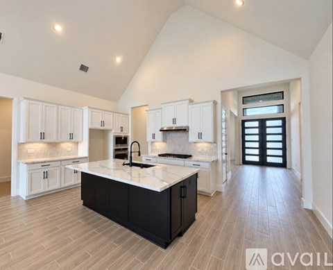 A spacious kitchen with white cabinets and a central island.