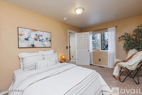 A bedroom with a large bed and a painting on the wall.