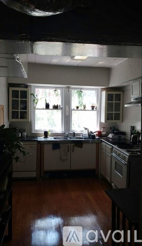A kitchen with wooden floors and white cabinets.