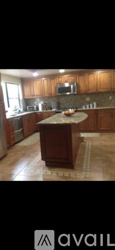 A kitchen with wooden cabinets and a granite countertop.