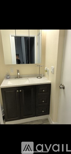 A bathroom with a sink, mirror, and cabinets.