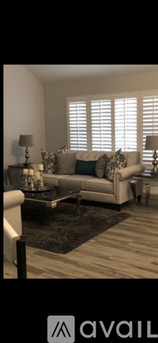 A living room with a couch, a coffee table, and a rug.