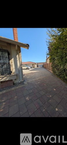A residential area with a brick pathway and houses on either side.