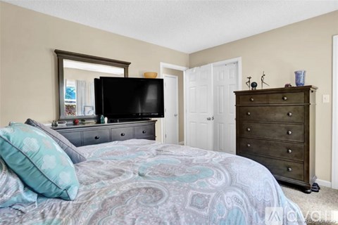 A bedroom with a bed, dresser, and mirror.