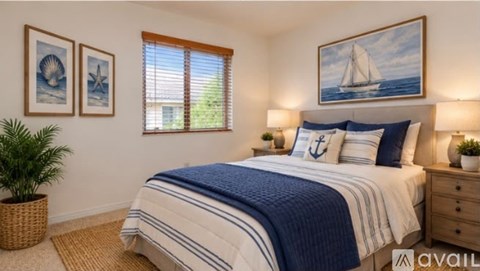 A bedroom with a bed, two lamps, and two pictures on the wall.