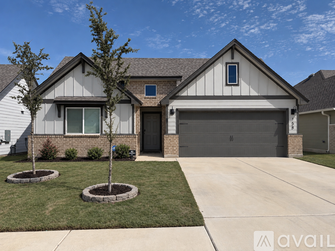 A house with a grey garage door and a brown roof.