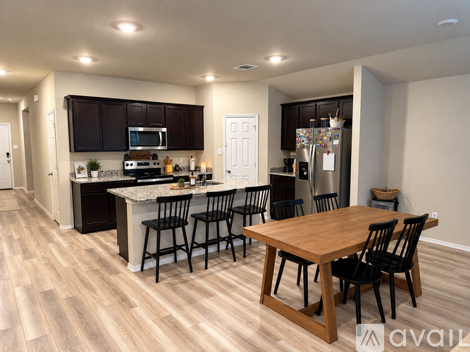 A kitchen with a table and chairs in the middle of the room.