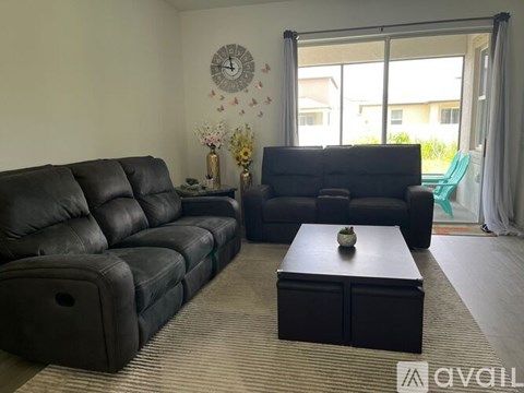 A living room with two black leather sofas and a coffee table.
