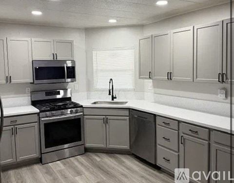 A kitchen with a stove, microwave, and cabinets.