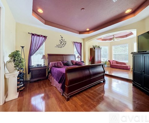 A bedroom with a large bed and a red chair.