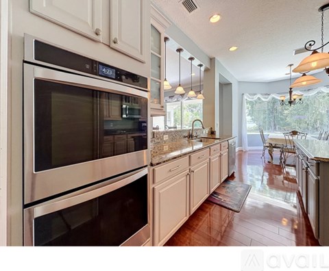 A modern kitchen with a stainless steel oven and white cabinets.