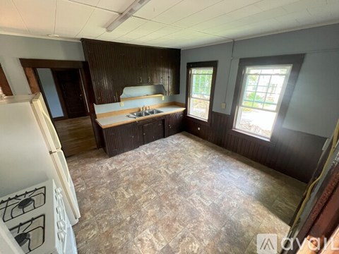A room with a kitchenette and a window.