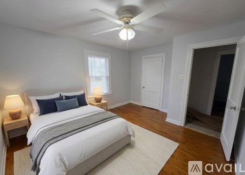 A bedroom with a large bed and a ceiling fan.