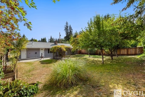 A house with a fence and trees in the yard.