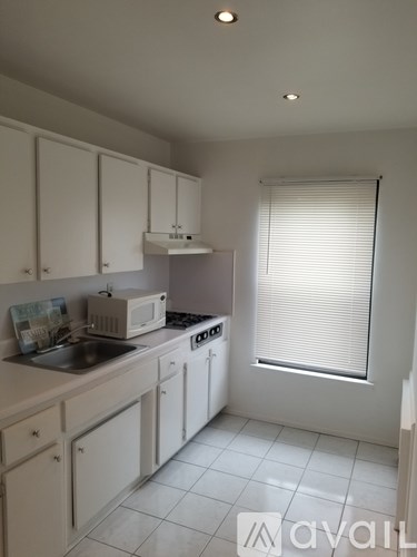 A kitchen with white cabinets and appliances.