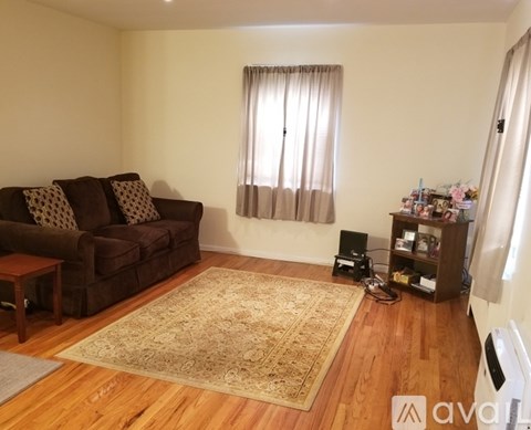 A living room with a brown couch and a rug.