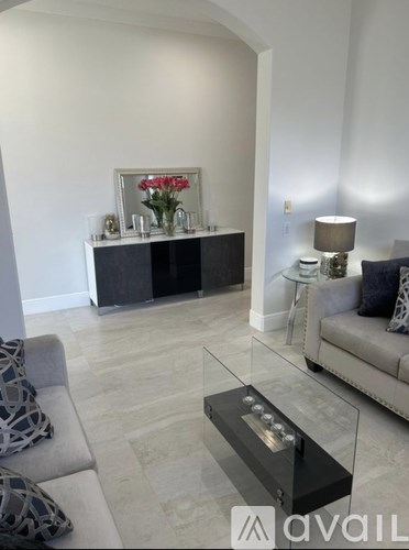 A living room with a grey sofa and a glass coffee table.