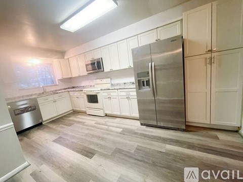 A kitchen with a refrigerator, microwave, and oven.