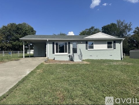 A house with a grey roof and a white fence.