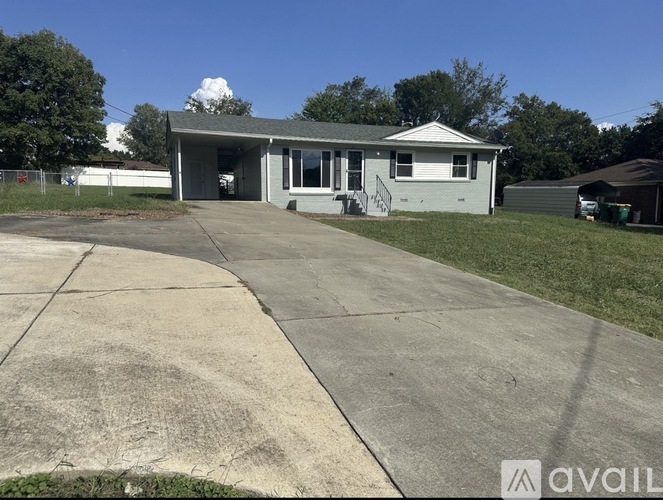 A house with a grey roof and a white garage door is available for sale.