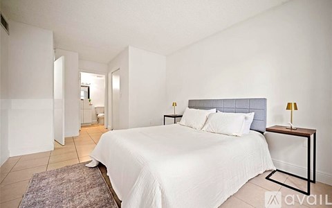 A bedroom with a bed, nightstand, and lamp.