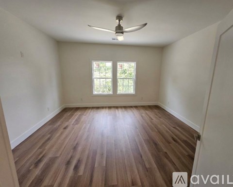 A room with wooden flooring and a ceiling fan.
