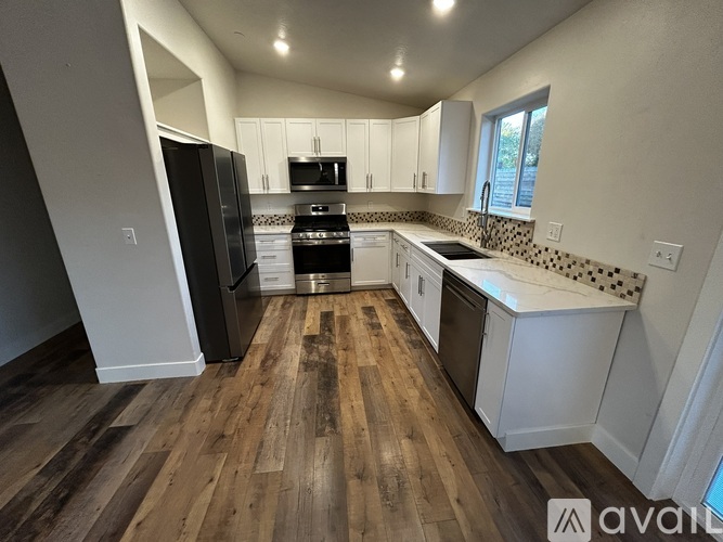 A kitchen with wooden floors and white cabinets is available for rent.