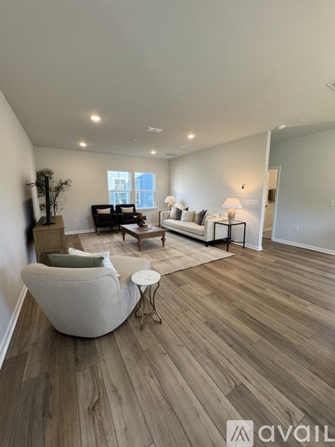 A living room with a white chair and a wooden floor.