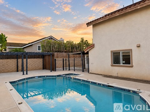 A pool in a backyard with a house in the background.
