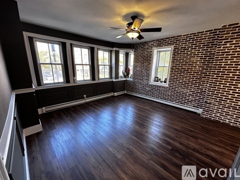 A room with wooden floors and a brick wall.