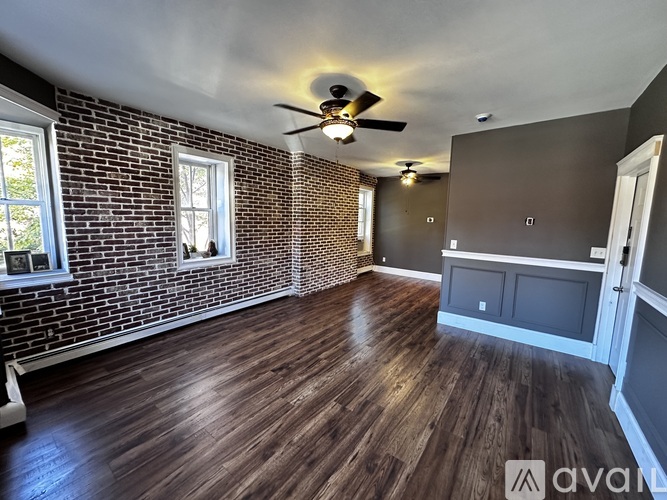 A room with wooden floors and a brick wall.