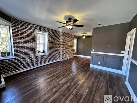 A room with wooden floors and a brick wall.