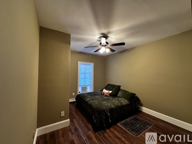 A bedroom with a bed and a ceiling fan.
