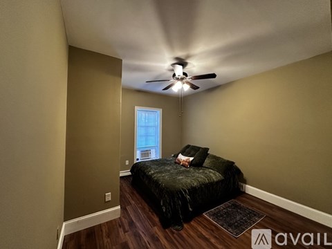 A bedroom with a bed and a ceiling fan.