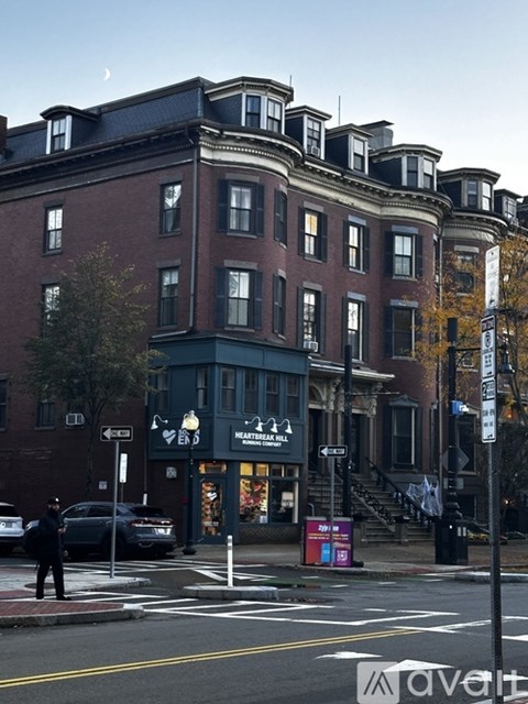 A street view of a city with a building and a police officer.