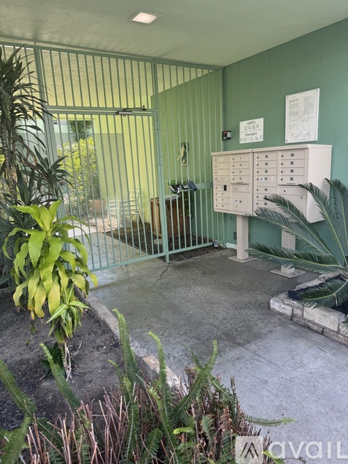 A green wall with a white board and a metal gate.