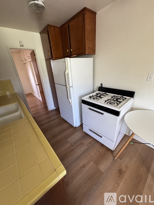 A kitchen with a white fridge and stove top.