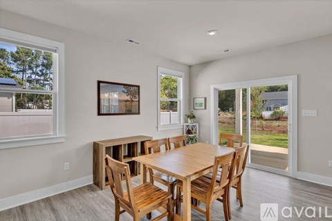 A dining room with a wooden table and chairs.