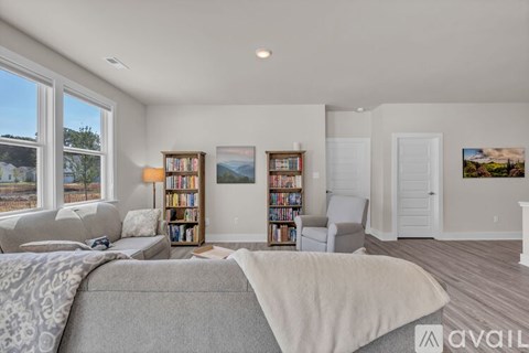 A bedroom with a large bed and a bookshelf filled with books.