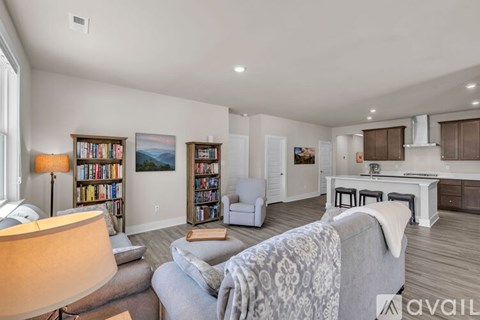 A living room with a grey couch and a bookshelf filled with books.