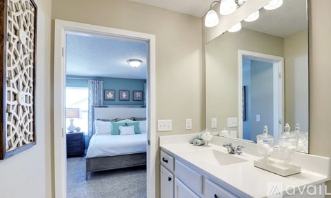 A bedroom with a large bed and a vanity with a mirror.