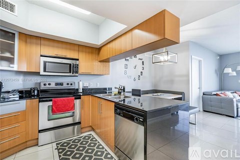 A kitchen with wooden cabinets and a black dishwasher.