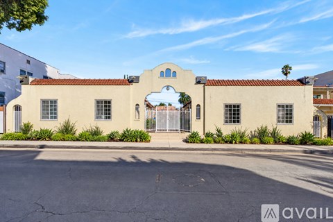 A building with a red tile roof and a white wall with a window and a door.