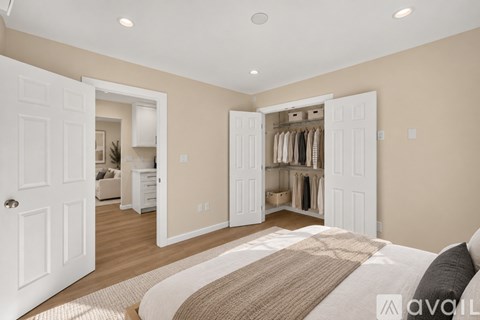 A bedroom with a large bed and a walk-in closet.